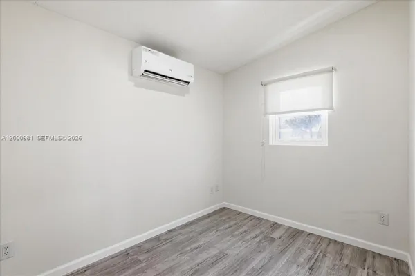 a view of a room with wooden floor and a window