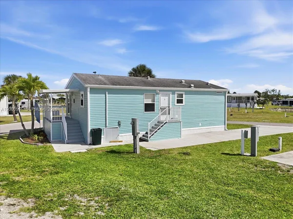 a view of a house with a yard and sitting area