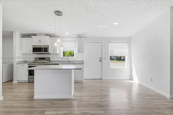 a kitchen with granite countertop a stove top oven and cabinets