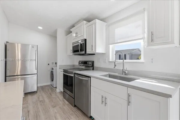a kitchen with a sink a refrigerator a washer and dryer