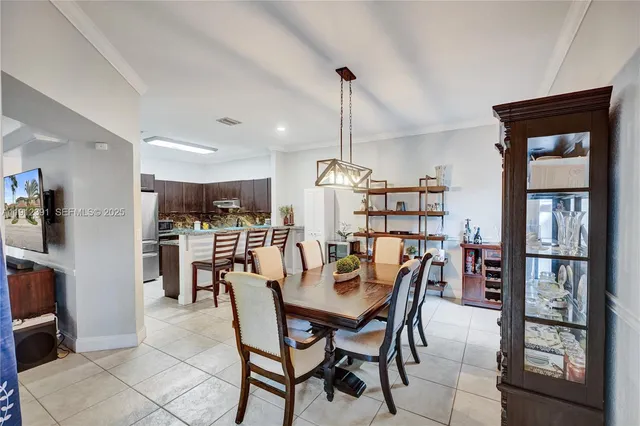 a view of a dining room and livingroom with furniture wooden floor a chandelier