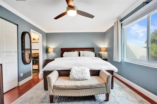 a bedroom with a bed and a large mirror on the dresser