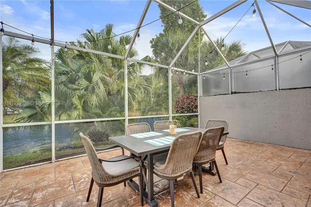 a view of a house with a large window and potted plants