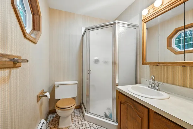 a bathroom with a granite countertop sink toilet and a mirror