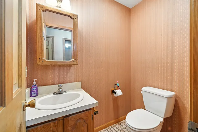 a bathroom with a sink a toilet and mirror