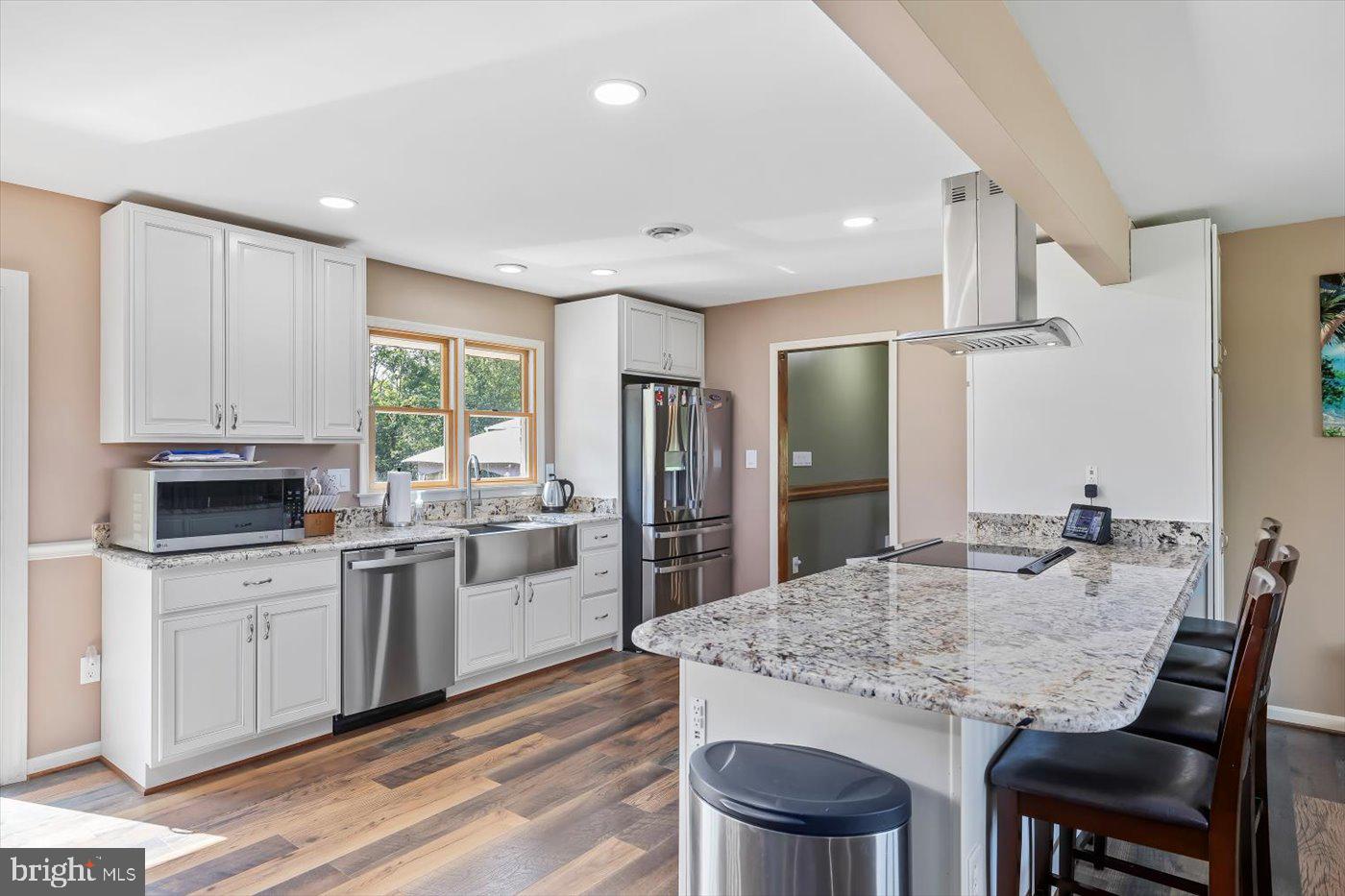 436 Castleton View Road Castleton, VA 22716 - Photo 16 of 66 a kitchen with kitchen island granite countertop a table chairs sink and refrigerator