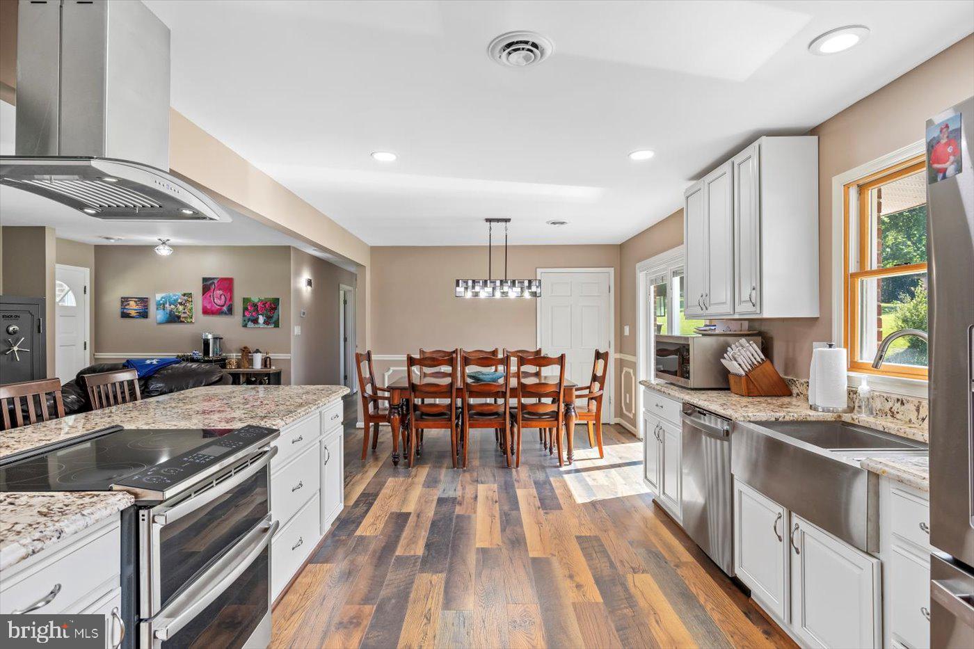 436 Castleton View Road Castleton, VA 22716 - Photo 19 of 66 a kitchen with stainless steel appliances granite countertop a stove oven a sink dishwasher a dining table and chairs with wooden floor