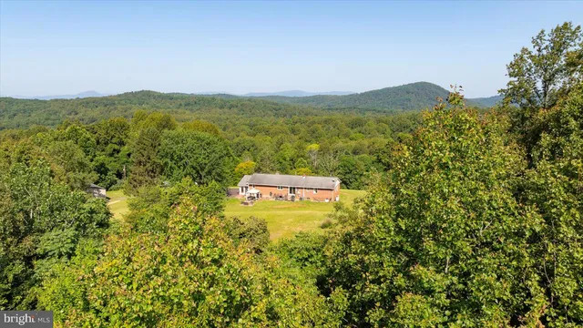 a living room with furniture a flat screen tv and floor to ceiling window