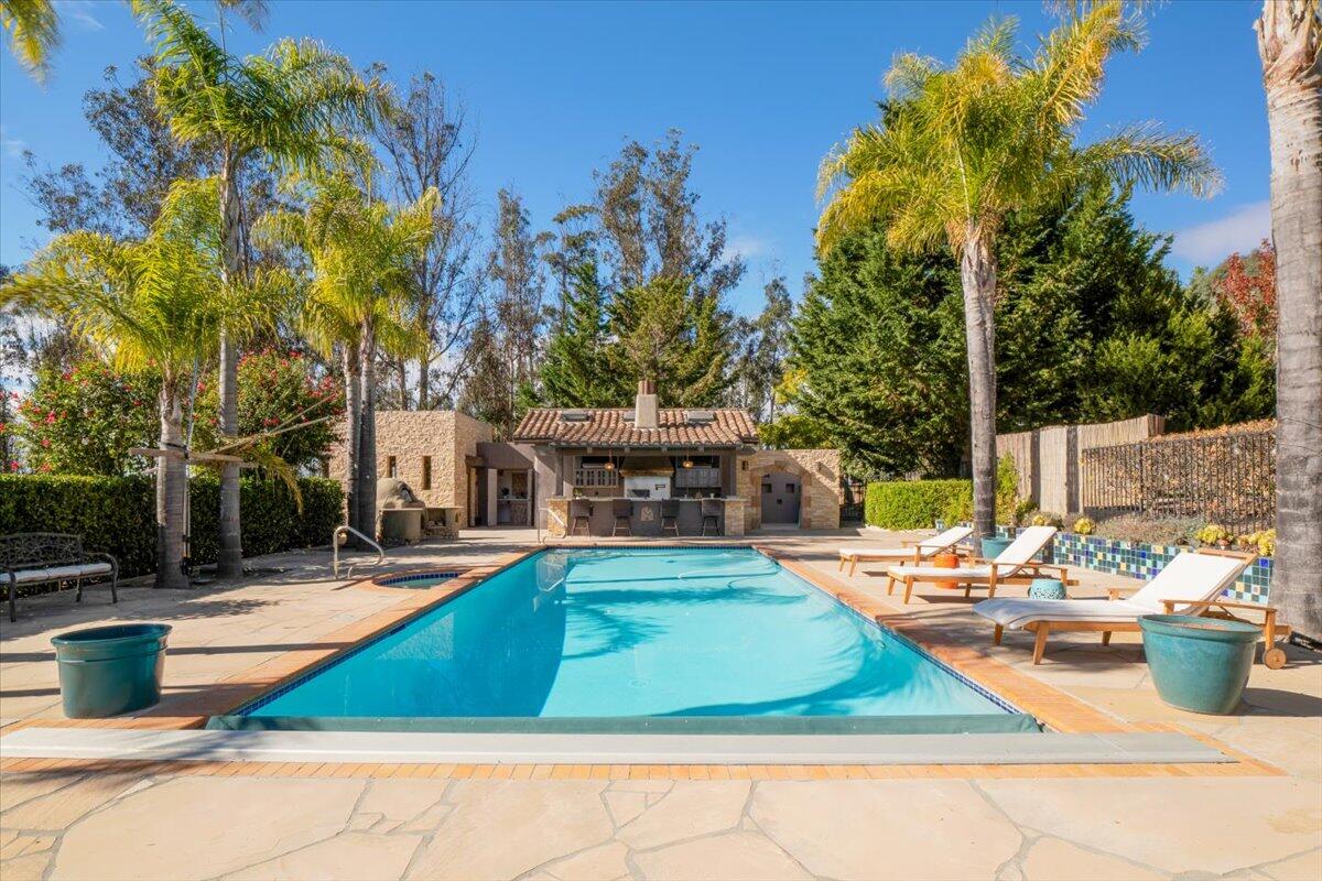 a view of a house with swimming pool and sitting area