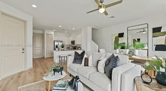 a living room with furniture white walls and a dining table