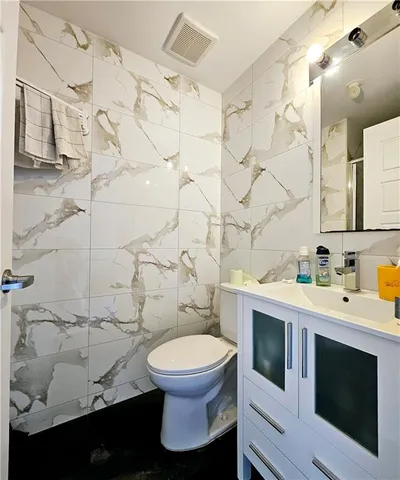a white toilet sitting next to a bathroom sink