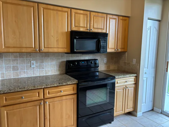 a kitchen with wooden cabinets and a stove top oven