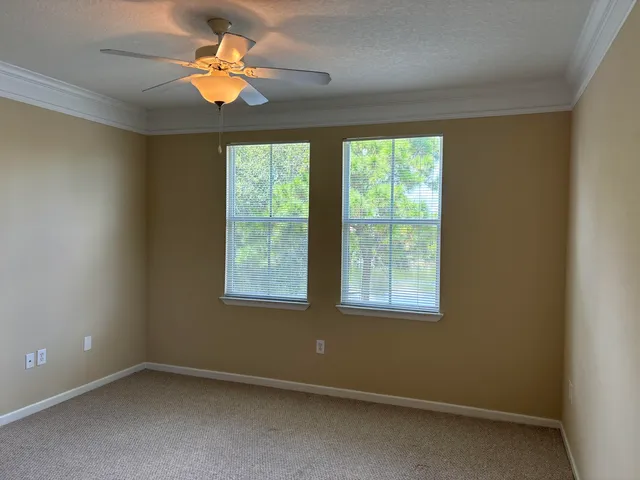 an empty room with a window and a fan