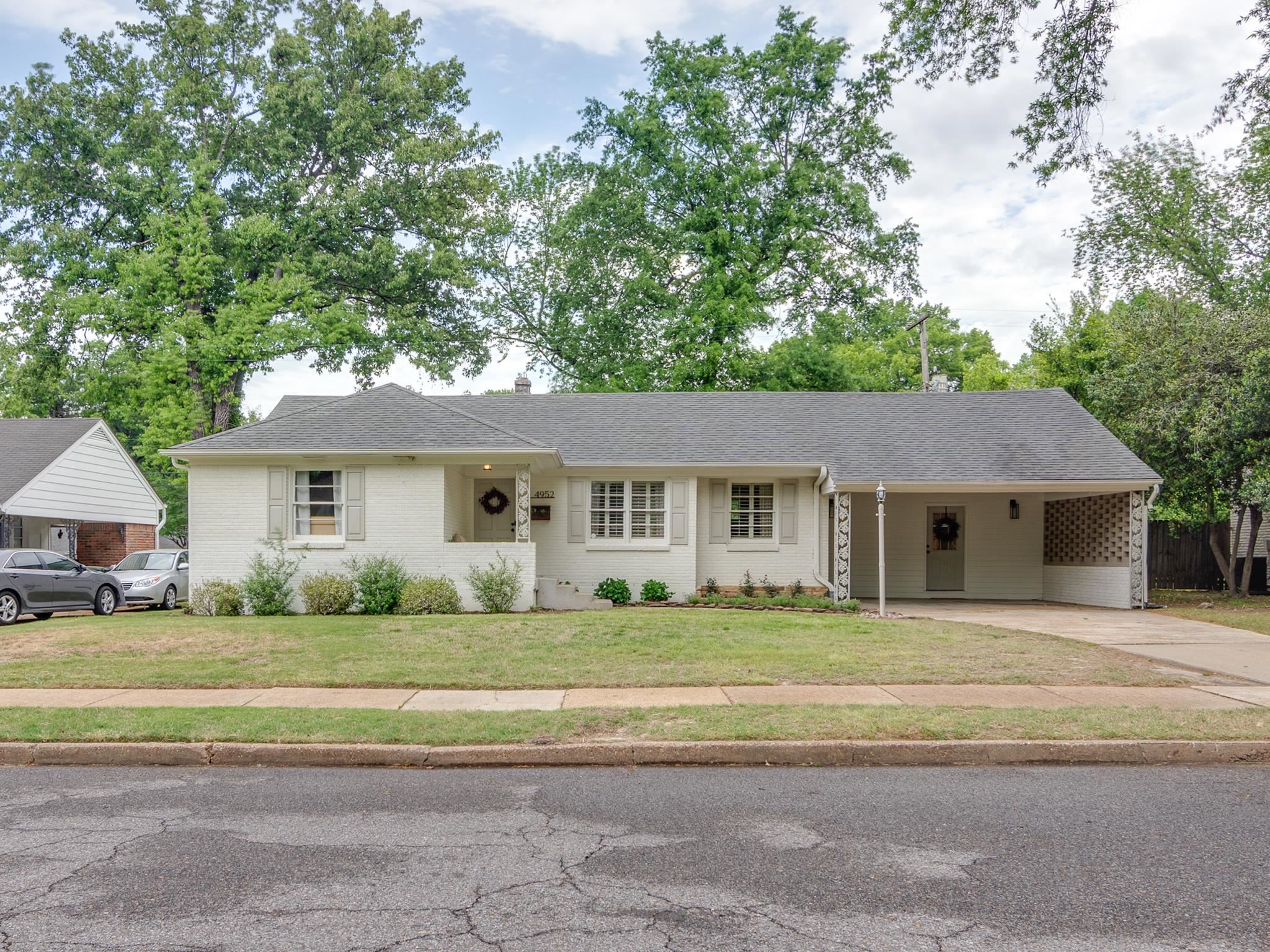 4952 Mockingbird Lane Memphis, TN 38117 - Photo 1 of 28 a front view of a house with a garden and tree