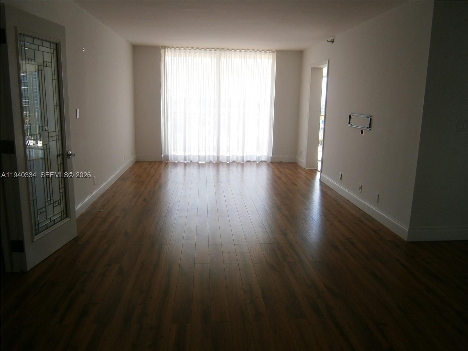 290 174th Street, Unit 1908 Sunny Isles Beach, FL 33160 - Photo 5 of 29 an empty room with wooden floor and windows