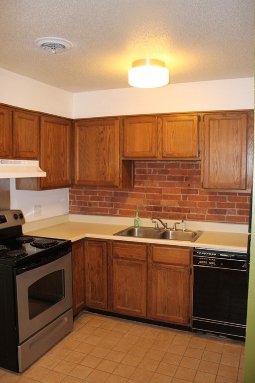 76 Temple Street, Unit 2 Springfield, MA 01105 - Photo 6 of 15 a kitchen with stainless steel appliances granite countertop a stove sink and cabinets