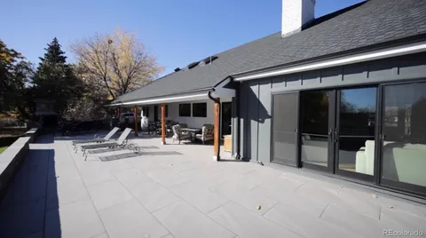 a view of a swimming pool with a lounge chair and trees in the background