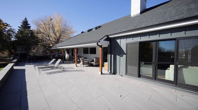 a view of a swimming pool with a lounge chair and trees in the background