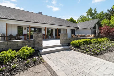 a front view of a house with lots of potted plants