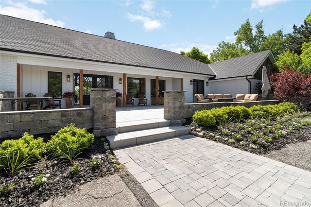 a front view of a house with lots of potted plants