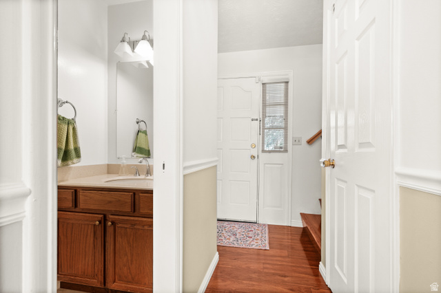 1650 Nichole Circle Sandy, UT 84093 - Photo 11 of 31 Foyer featuring wood-finish flooring, a paneled entry door with sidelight, and a staircase with a wood handrail