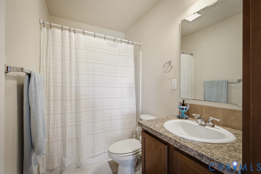 18262 Seals Road Bowling Green, VA 22427 - Photo 29 of 50 a bathroom with a granite countertop sink toilet and a mirror