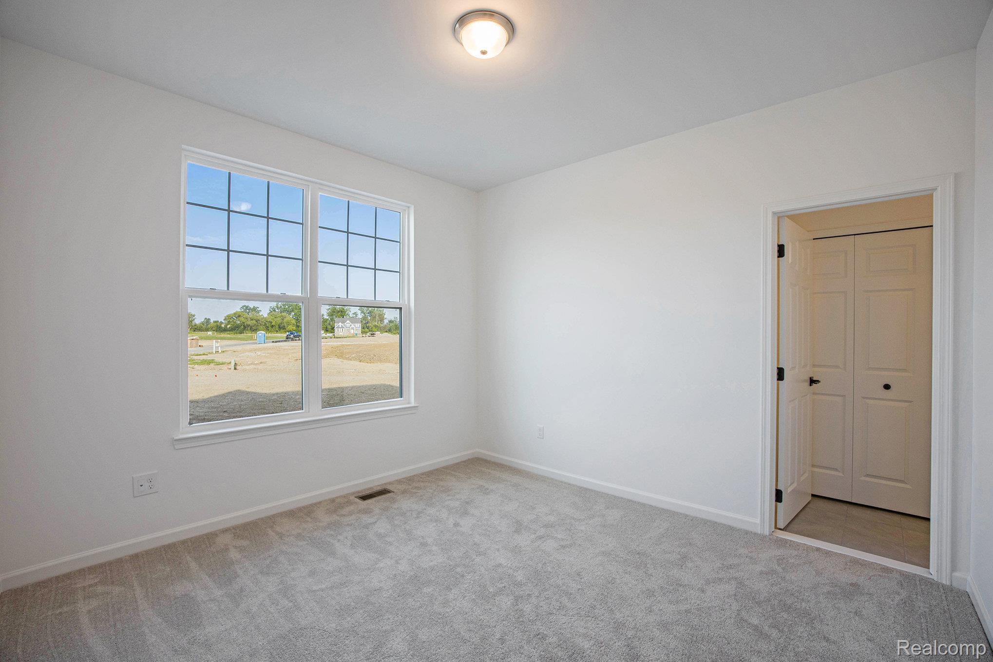 68788 Place Road New Haven, MI 48050 - Photo 13 of 29 Empty room with light colored carpet and baseboards