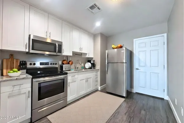 a kitchen with stainless steel appliances granite countertop a refrigerator stove a sink and a microwave