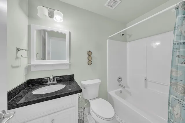 a spacious bedroom with a bed and a chandelier