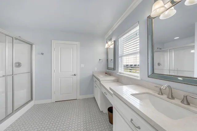 a spacious bedroom with a large bed and a chandelier