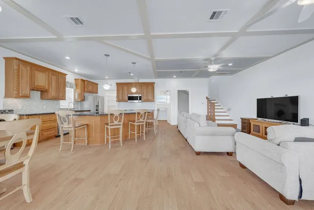 a kitchen with stainless steel appliances granite countertop a sink a stove and a wooden cabinets