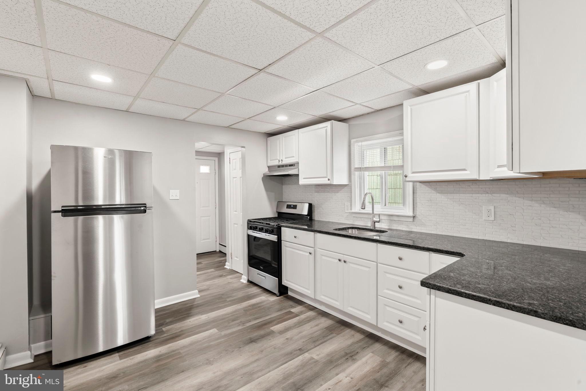 1363 Green Street Marcus Hook, PA 19061 - Photo 12 of 26 a kitchen with granite countertop a refrigerator sink and cabinets