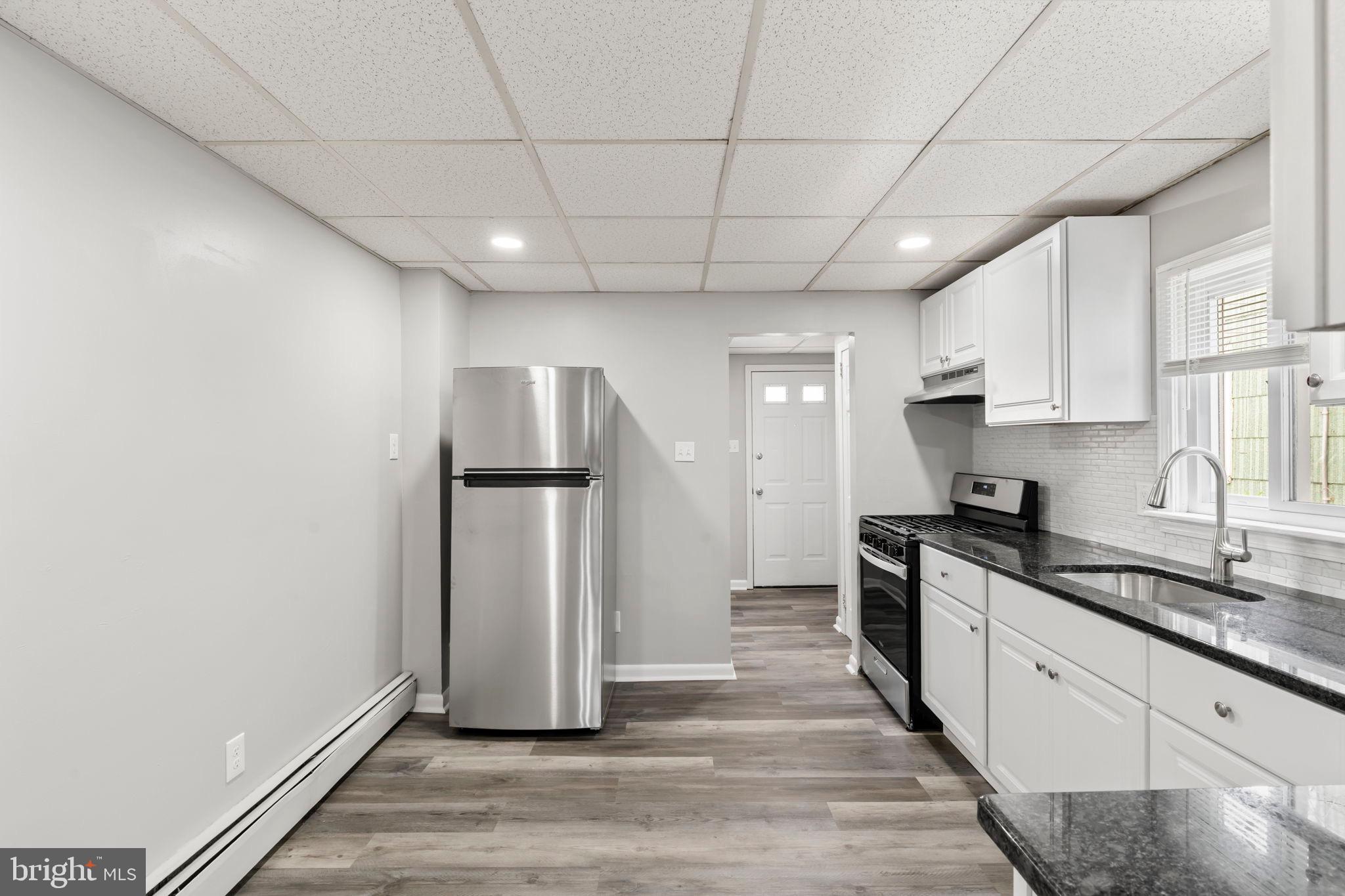 1363 Green Street Marcus Hook, PA 19061 - Photo 13 of 26 a kitchen with granite countertop a refrigerator and a stove top oven