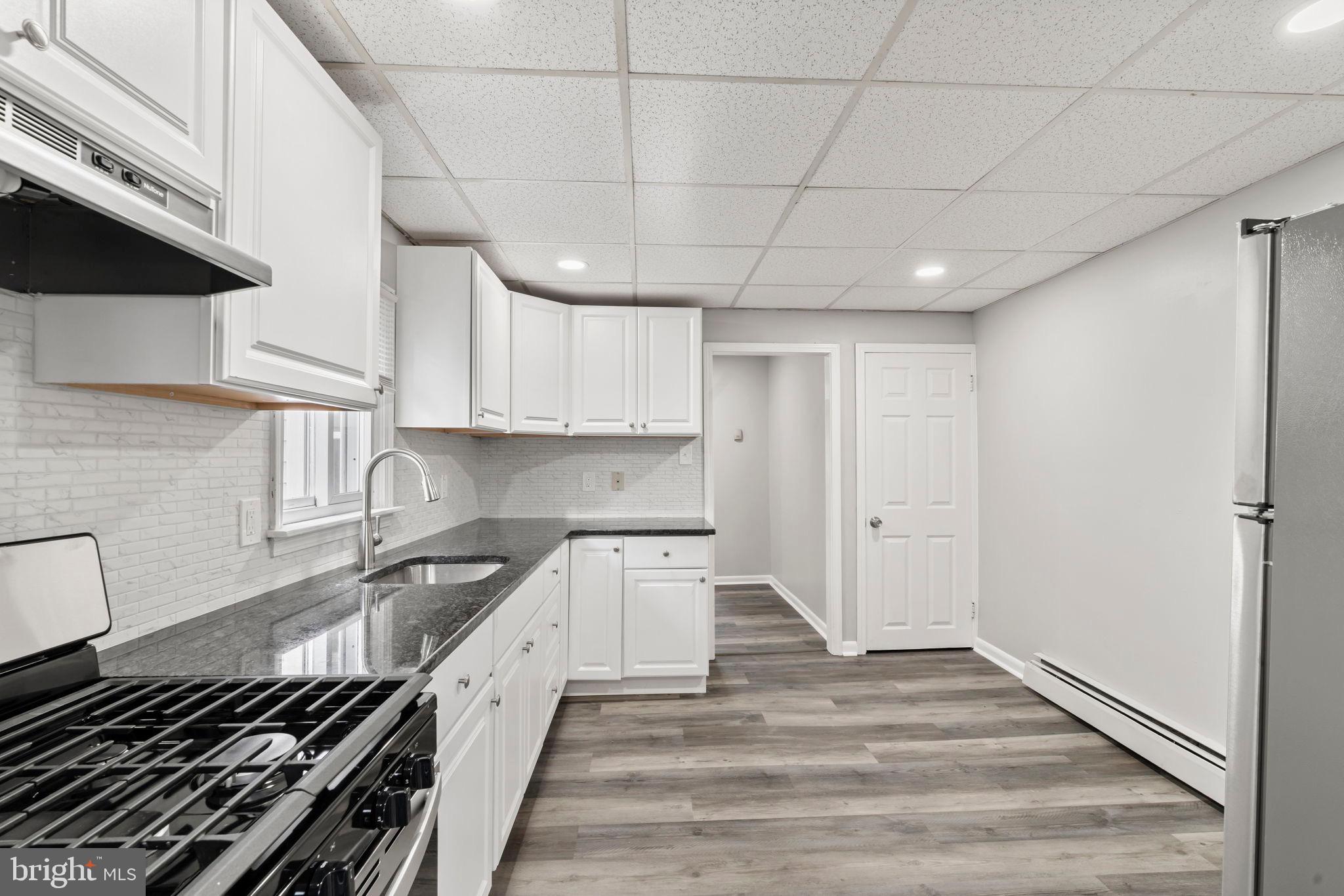 1363 Green Street Marcus Hook, PA 19061 - Photo 10 of 26 a kitchen with granite countertop a stove and a sink