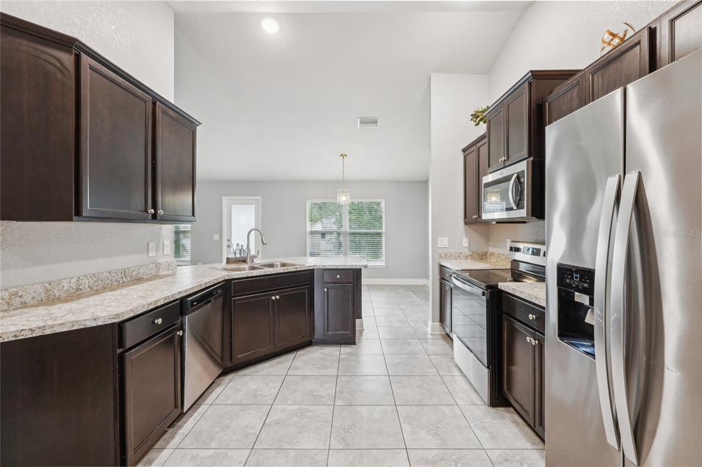 5134 Jenson Avenue Spring Hill, FL 34608 - Photo 13 of 49 a large kitchen with stainless steel appliances granite countertop a refrigerator and a sink