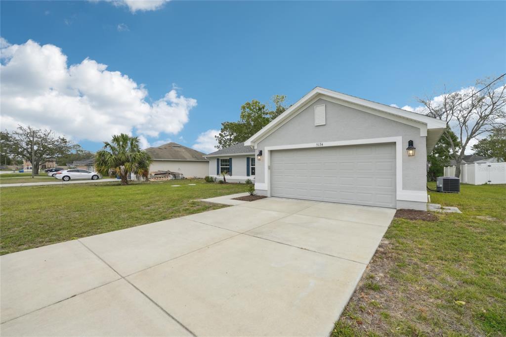 5134 Jenson Avenue Spring Hill, FL 34608 - Photo 2 of 49 a front view of a house with a yard and garage