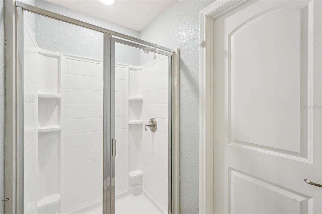 5134 Jenson Avenue Spring Hill, FL 34608 - Photo 23 of 49 a bathroom with a glass shower door