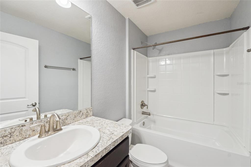 5134 Jenson Avenue Spring Hill, FL 34608 - Photo 27 of 49 a bathroom with a granite countertop sink toilet tub and shower