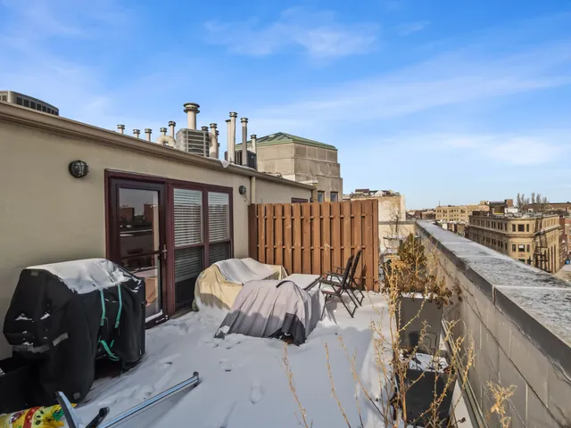 a view of roof deck with two couches and potted plants