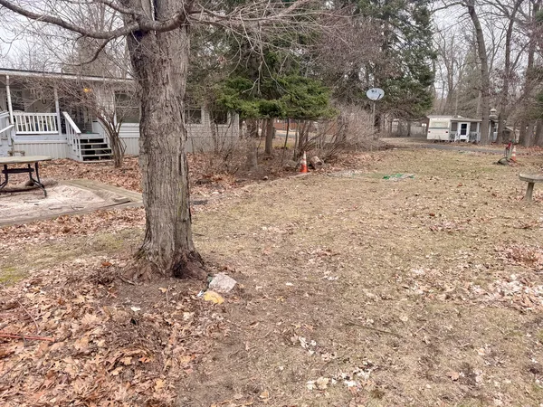 a backyard of a house with large trees and outdoor seating