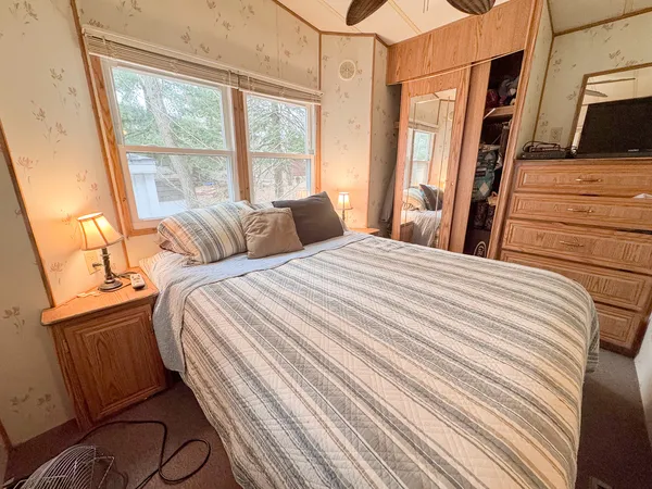 a bedroom with a bed a flat screen tv and a large window