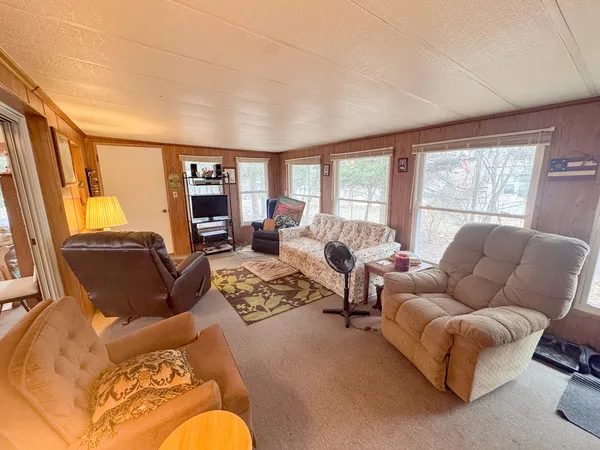 a living room with furniture fireplace and a large window