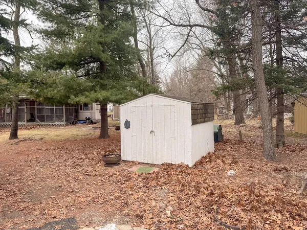 a backyard of a house with large trees and wooden fence