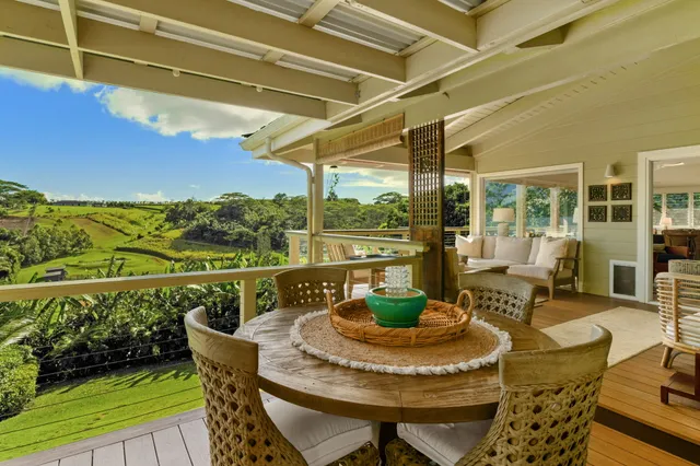 a view of a balcony with dining table and chairs