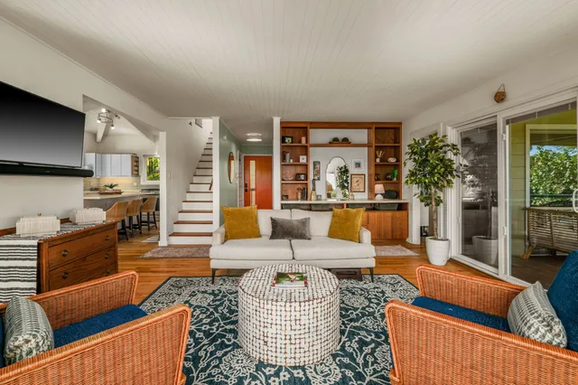 a living room with furniture potted plant and a large window