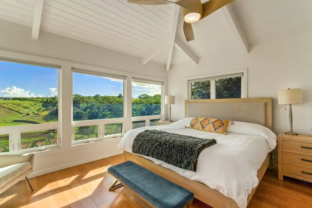 a bedroom with a bed and a large window with outer view
