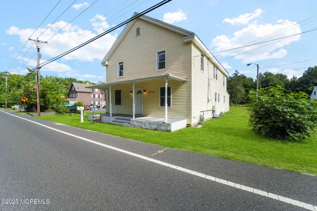a view of a house with a yard and potted plants