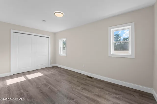 a view of a small space with wooden floor and a window