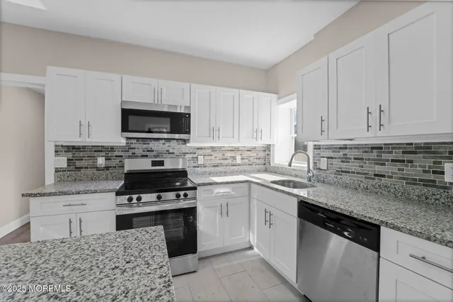 a kitchen with cabinets appliances a sink and a counter top space