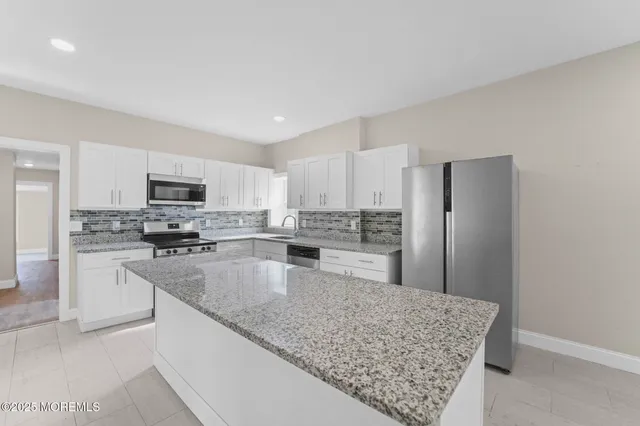 a kitchen with stainless steel appliances granite countertop a refrigerator sink and stove